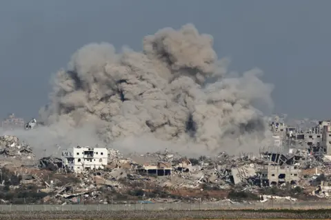 AFP A picture taken from southern Israel near the border with the Gaza Strip on December 9, 2023, shows smoke rising above buildings during an Israeli strike in Gaza, amid continuing battles between Israel and the militant group Hamas.