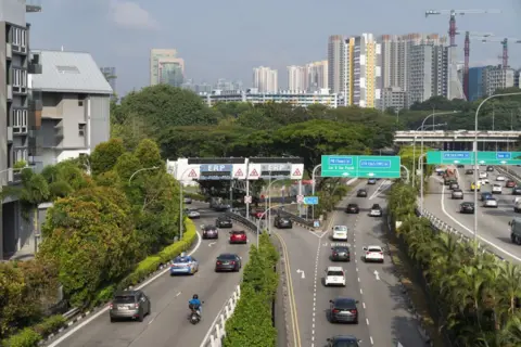 Bloomberg via Getty Images Vehicles go through an electronic road pricing gantry at the junction of two major expressways in Singapore