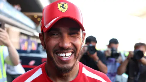 Lewis Hamilton smiles while celebrating his victory for Ferrari in the Barcelona-Catalunya Grand Prix