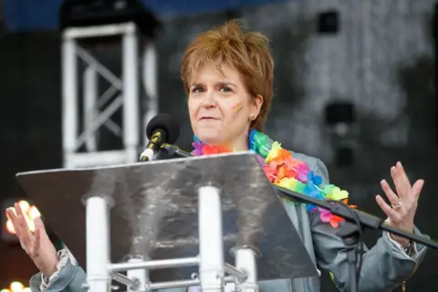 Getty Images Nicola Sturgeon with a colourful garland over her shoulders addresses the 2017 Glasgow Pride event