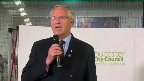 BBC Chris Nelson speaking into a microphone