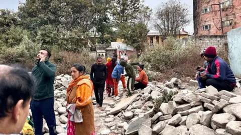 Getty Images Penduduk Nepal berkumpul di luar ruangan di lingkungan sekitar