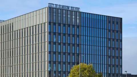 Getty Images A modernist grey building, the exterior comprised of large glass windows, with a sign on top reading "city of Glasgow college".