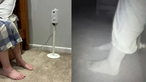 Side-by-side photos of a person’s feet on a carpeted floor. The left image shows the person sitting on the edge of a bed with bare feet, next to a white stand holding an electronic device. The right image is a night vision or infrared view of the same scene, focusing on the feet.