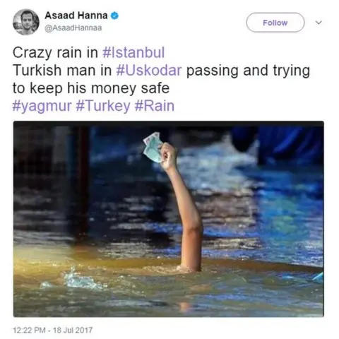 AFP/Getty Images/Asaad Hanna An hand holding money raised above a person submerged under water