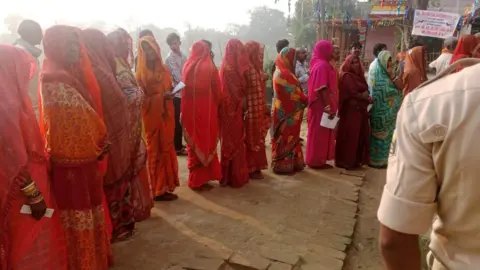 Election Commission of India Women in sarees lining up outside a poll booth in Bihar