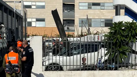 Reuters Part of a rocket sticks retired  from a parked car   successful  the Israeli municipality  of Raanana, adjacent   Tel Aviv, cardinal  Israel (6 November 2024)