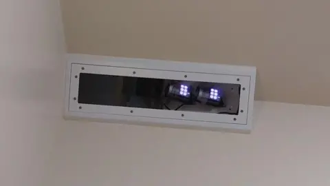 Name for Oxevision cameras to be banned in psychological well being sufferers' bedrooms The Oxevision technology - which is an infrared camera - placed near the ceiling in the corner of a bedroom. It is in a white rectangle box and small white lights can be seen at one end.