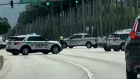 Several police cars block a large road