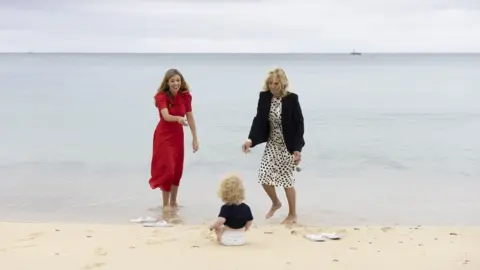 Getty Images Carrie Johnson plays with her son Wilfred on the beach with Jill Biden