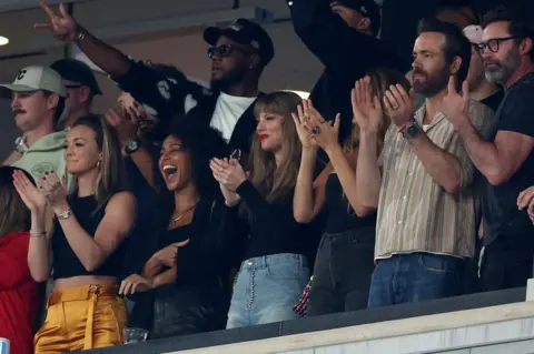 Getty Images Singer Taylor Swift, Actor Ryan Reynolds and Actor Hugh Jackman cheer prior to the game between the Kansas City Chiefs and the New York Jets at MetLife Stadium on October 01, 2023