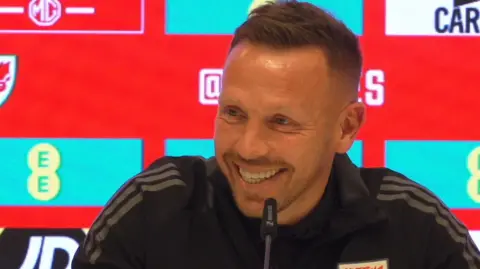 Craig Bellamy smiles as he speaks to the media