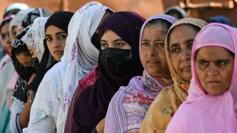 Getty Images Voters queue up at a polling station to cast their votes during the third and final phase of voting for local government elections in Bandipora on October 1, 2024. (Photo by TAUSEEF MUSTAFA / AFP) (Photo by TAUSEEF MUSTAFA/AFP via Getty Images)