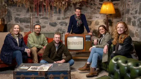 Landward presenters Arlene Stuart, Shahbaz Majeed, Cammy Wilson, Dougie Vipond, Anne McAlpine and Rosie Morton in a room, with a TV which says 'Landward 50'.