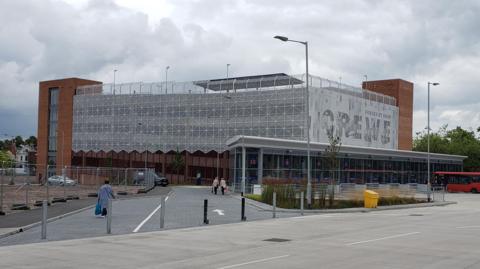The exterior of Crewe multi-storey car park can be seen. It is next door to a bus station
