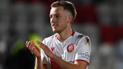 Stevenage midfielder Harvey White applauds the team's supporters