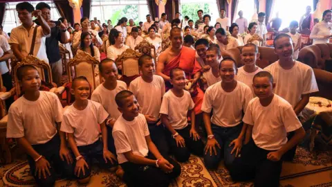 AFP/Getty Thai coach Ekkapol Chantawong (C) and all 12 members of the "Wild Boars" football team pose for a photo together after a ceremony to mark the end of the 11 players's retreat as novice Buddhist monks
