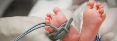 Getty Images Baby's feet in hand
