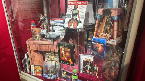 A cabinet showing a selection of games, toys and magazines