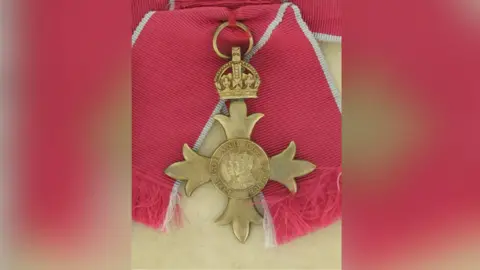 Nottingham Women's History Group An OBE laid on a light coloured background