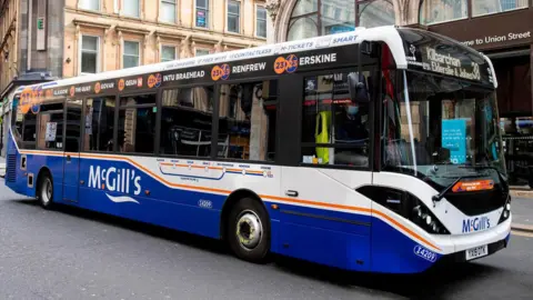 A blue and white single-decker McGill's bus driving on Union Street in Glasgow