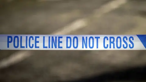 A close-up photo of a blue and white police tape