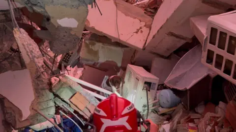 Lancashire Fire and Rescue Service People in hard hats digging through rubble
