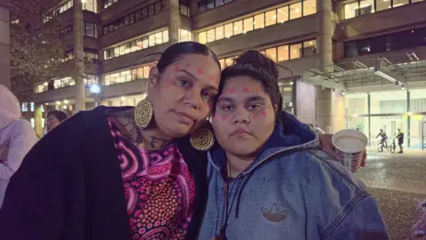 BBC/Lana Lam Two women look into the camera with their heads pressed together