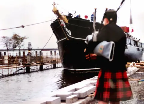 Paul Simpson A piper welcomes the ship on its final voyage