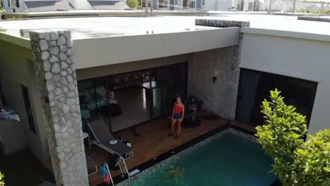 West Midlands Police A woman standing on the deck of a Thai villa