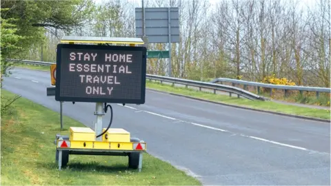 Asurobson / Getty Images Road sign indicating essential travel only due to the Covid-19 lockdown