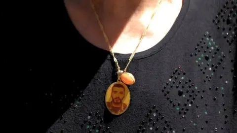 Reuters A mother in Homs with a locket of her lost son
