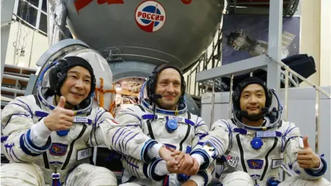 Getty Images Russian cosmonaut Alexander Misurkin (C) and space flight participants - Japanese billionaire Yusaku Maezawa (L) and his assistant Yozo Hirano - attend a training ahead of the expedition to the International Space Station, in Star City outside Moscow on 14 October 2021.