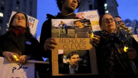 Reuters Bahij Chancey (C) stands with a sign featuring his friend, Nicholas Cleves, during a vigil in Foley Square in Manhattan, New York on 1 November 2017.