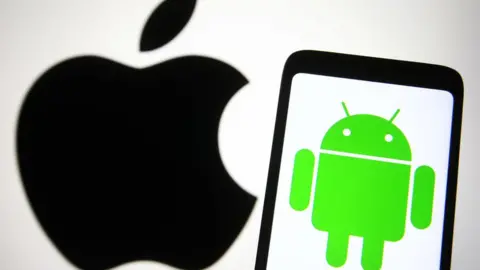 Getty Images The Apple logo is displayed on a background while the Android logo is on a phone closer to the camera