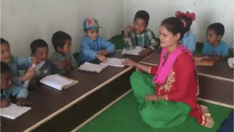 United World Schools/States of Guernsey Teacher with children in Nepal