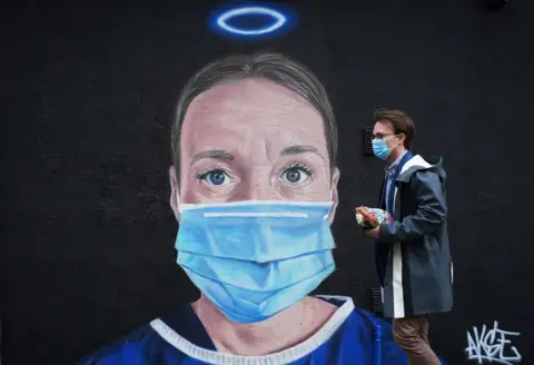 Getty Images A mural by street artist Akse depicting an NHS nurse with a halo adorns - Manchester's northern quarter on June 03, 2020