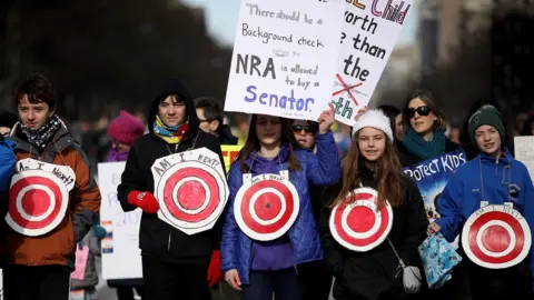 Getty Images Students from Centreville, Virginia wear targets on their chests as they arrive for the March for Our Lives rally in Washington DC, 24 March 2018