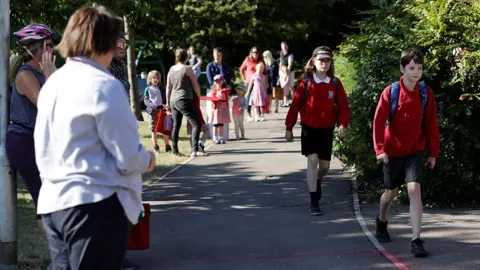 Eddie Keogh / Reuters Parents and children arrive at Watlington Primary School