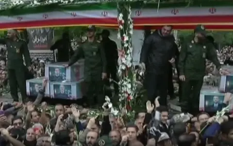 Mourners gather in Tabiz, gathering around a lorry carrying soldiers and pictures of those killed in the helicopter crash