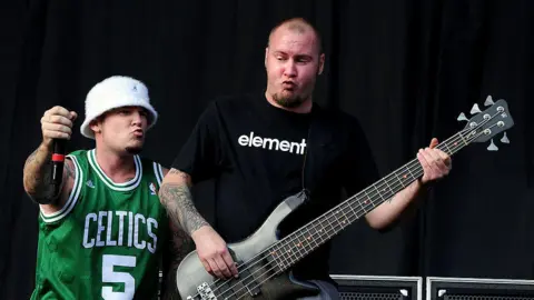 Shirlaine Forrest/WireImage Durst is wearing a green Celtics jersey and white hat and Rivers has on a black Tshirt