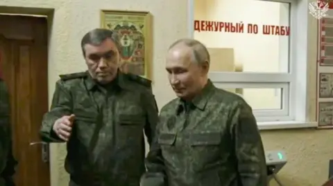 Image taken from a handout video provided by the Russian Presidential Press Service shows Russian President Vladimir Putin (R) with Russian Chief of General Staff Valery Gerasimov