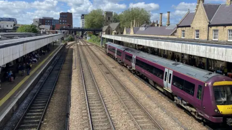 Tren morado en el andén de una estación de tren