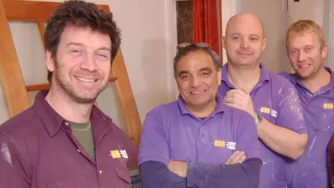 Picture shows L-R: Nick Knowles, Billy Byrne, Julian Perryman and Chris Frediani, some of the DIY SOS team in a house being renovated and all wearing purple dusty shirts
