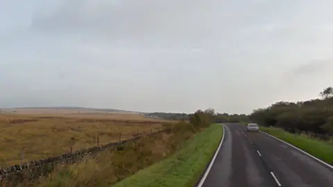 A long rural road under a cloudy sky