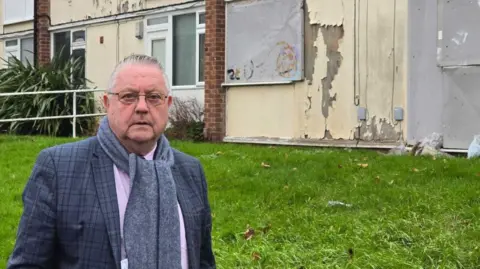 LDRS Man in a suit outside a council house
