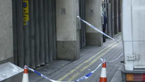 Pacemaker Press The side of the Northern Bank showing red and white cones and police tape. AT the right hand side there is a white van.