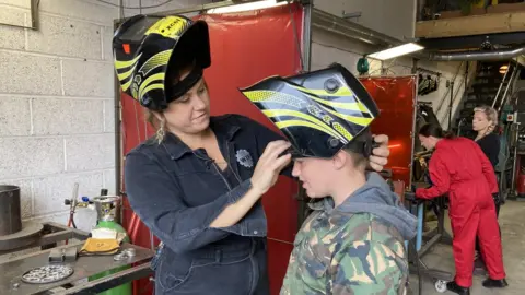 BBC Woman and young boy wearing protective helmets