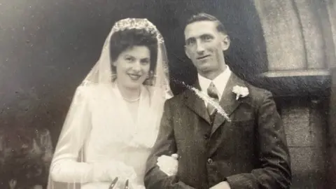 Peter Watts A black and white image of a man and a woman on their wedding day 