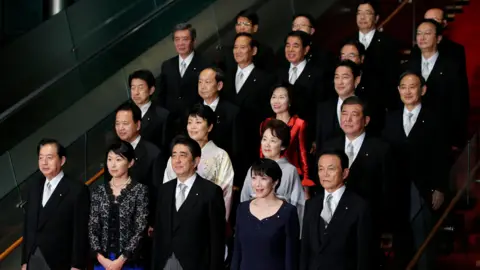 Bloomberg via Getty Images Shinzo Abe Pose for a group photograph with members of his new cabinet at the Prime Minister's official residence in Tokyo
